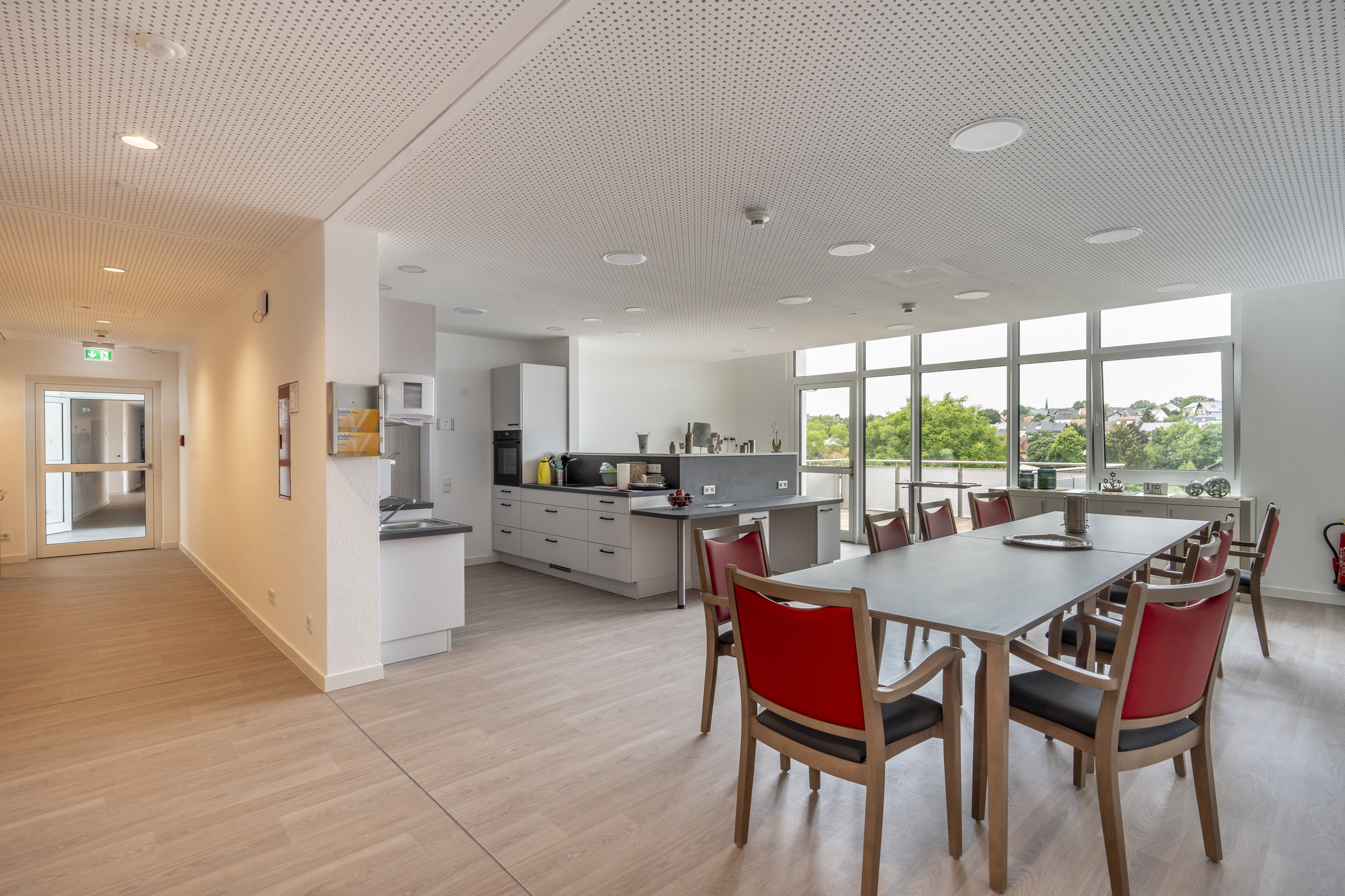 Großzügiger Wohn- und Essbereich im Meierhof mit offener Küche, langer Tafel und Blick ins Grüne